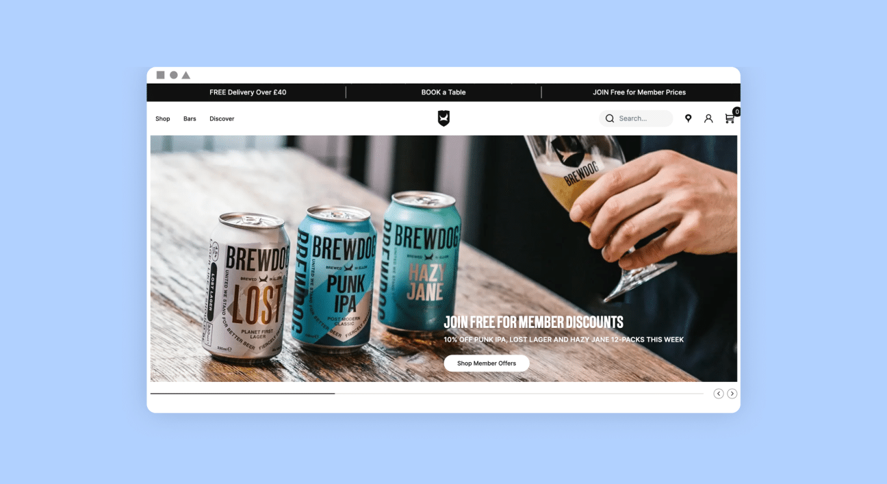 The image displays a webpage from an online store or bar, featuring BrewDog craft beers. The website header offers options like "Shop," "Bars," and "Discover," and advertises "FREE Delivery Over £40," an option to "BOOK a Table," and an invitation to "JOIN Free for Member Prices."In the main visual area of the site, three cans of BrewDog beers are presented: 'LOST Lager,' 'PUNK IPA,' and 'HAZY JANE.' Beside the cans, a person's hand is shown pouring a beer into a glass, capturing the act of enjoying a fresh brew.A promotional banner highlights "JOIN FREE FOR MEMBER DISCOUNTS" followed by an offer: "10% OFF PUNK IPA, LOST Lager and HAZY JANE 12-PACKS THIS WEEK." There's also a call to action button that says "Shop Member Offers."